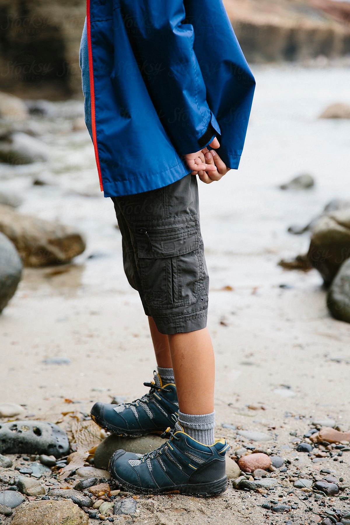 Boy standing on shore during low tide