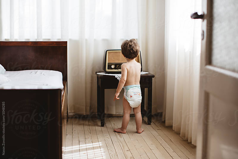1 year old boy playing with a vintage radio