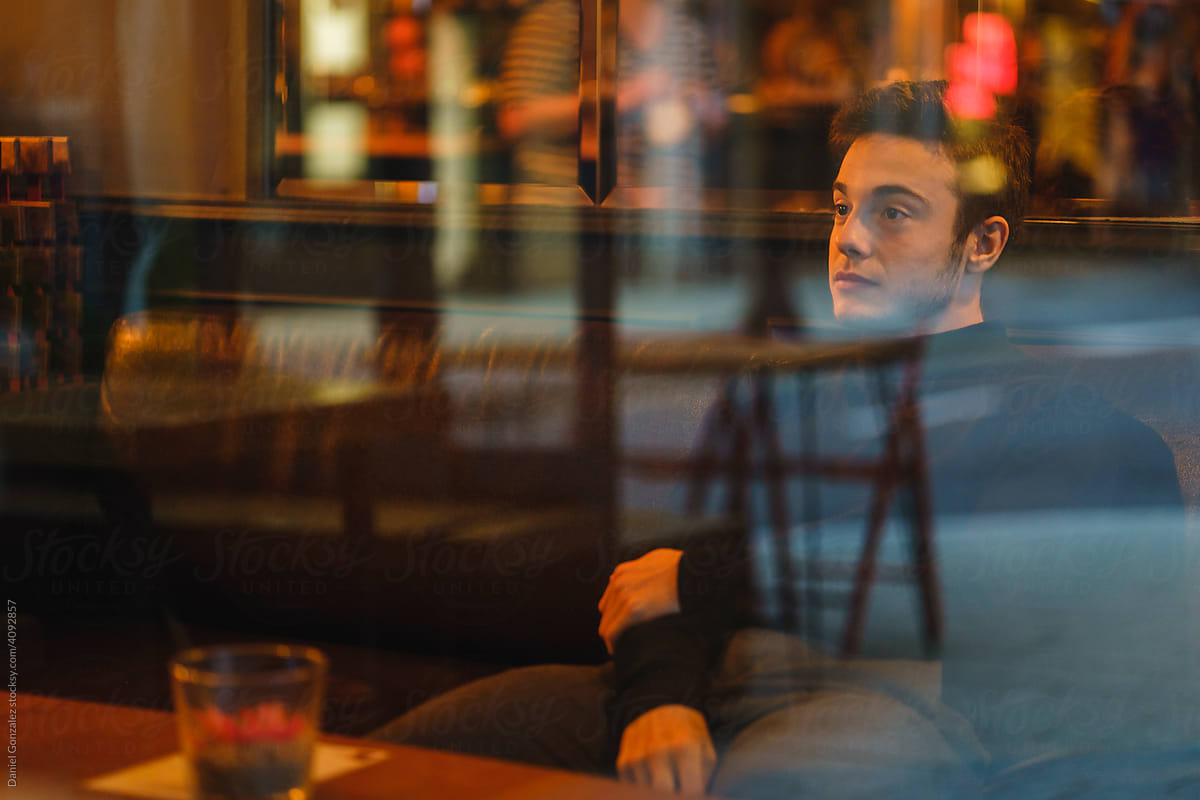A boy sitting inside a bar