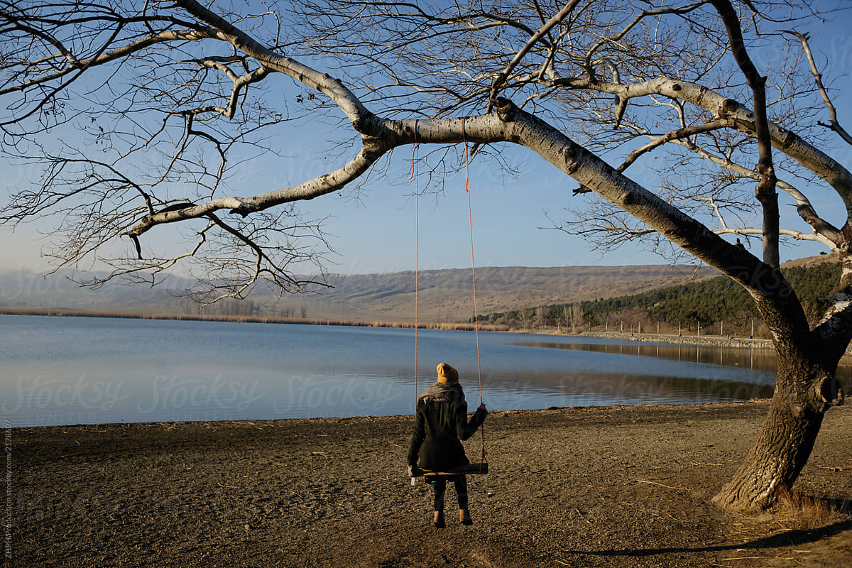 Woman at the lake in fall season on seesaw