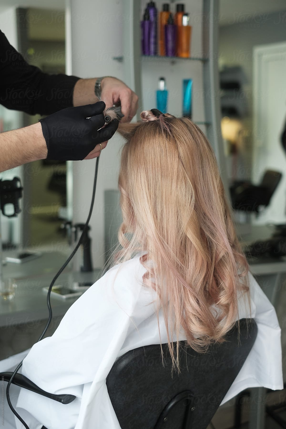 Hairdresser Working On A Customer With Curling Iron