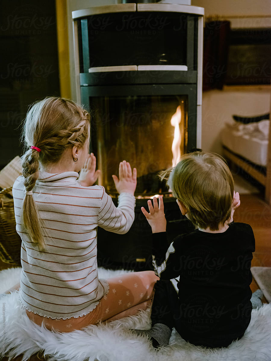 Children getting warm at the fireplace