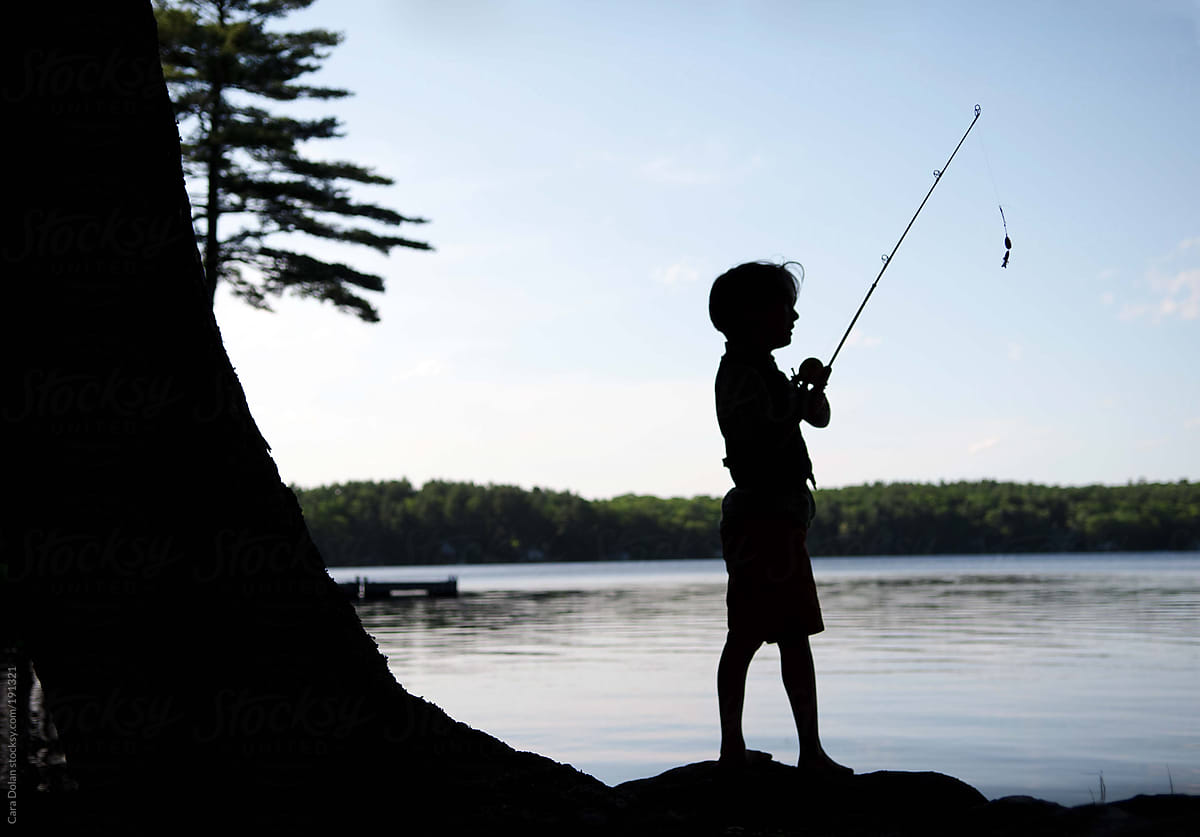 Silhouette Of A Boy Fishing On A Lake At Sunset by Stocksy Contributor  Cara Dolan - Stocksy