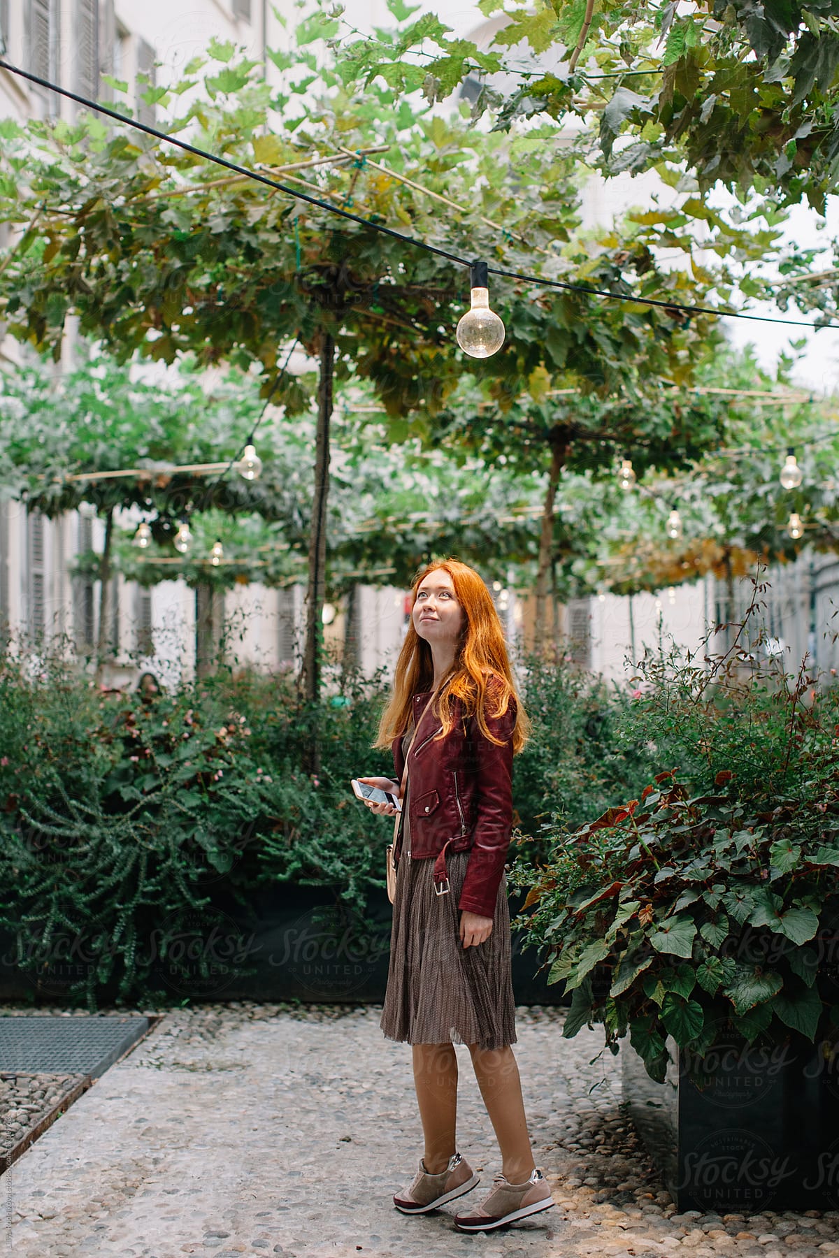 Dreamy portrait of stylish redhead girl in the garden