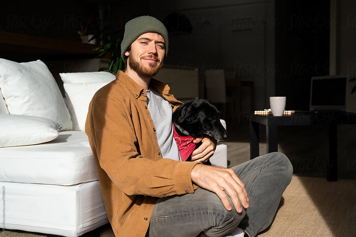 man with dog at home sofa with coffee