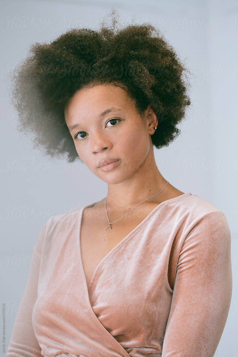 Portrait of young woman in studio with afro