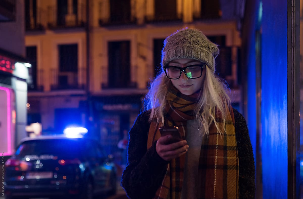 Casual woman watching phone outside in evening