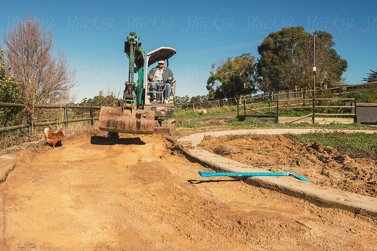 garden makeover, a man uses an excavator to dig up soil