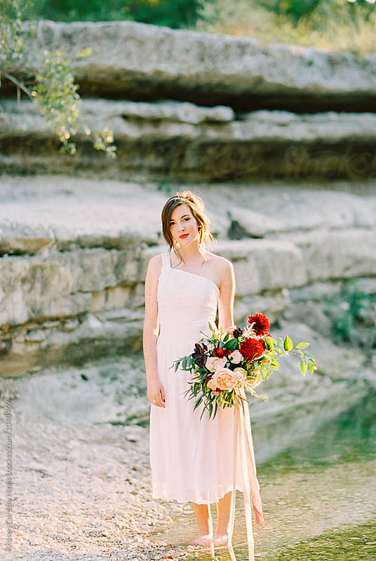Bridal inspiration / Woman in a white dress standing by water