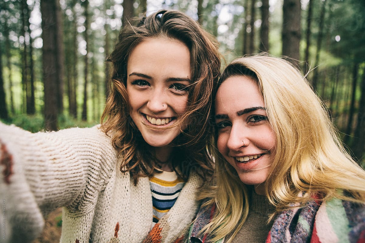 Two Teenage Girls Taking A Selfie In Woodland By Stocksy Contributor 