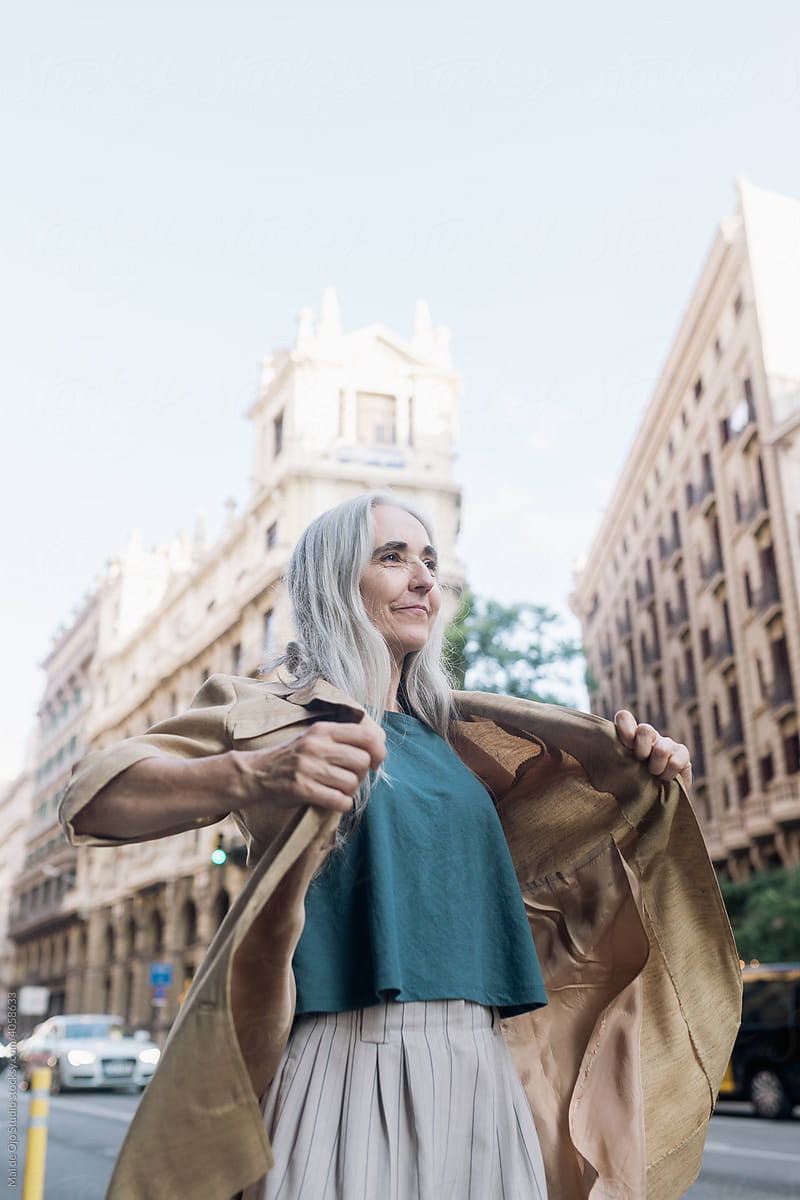 Grey-haired woman in a coat in the city