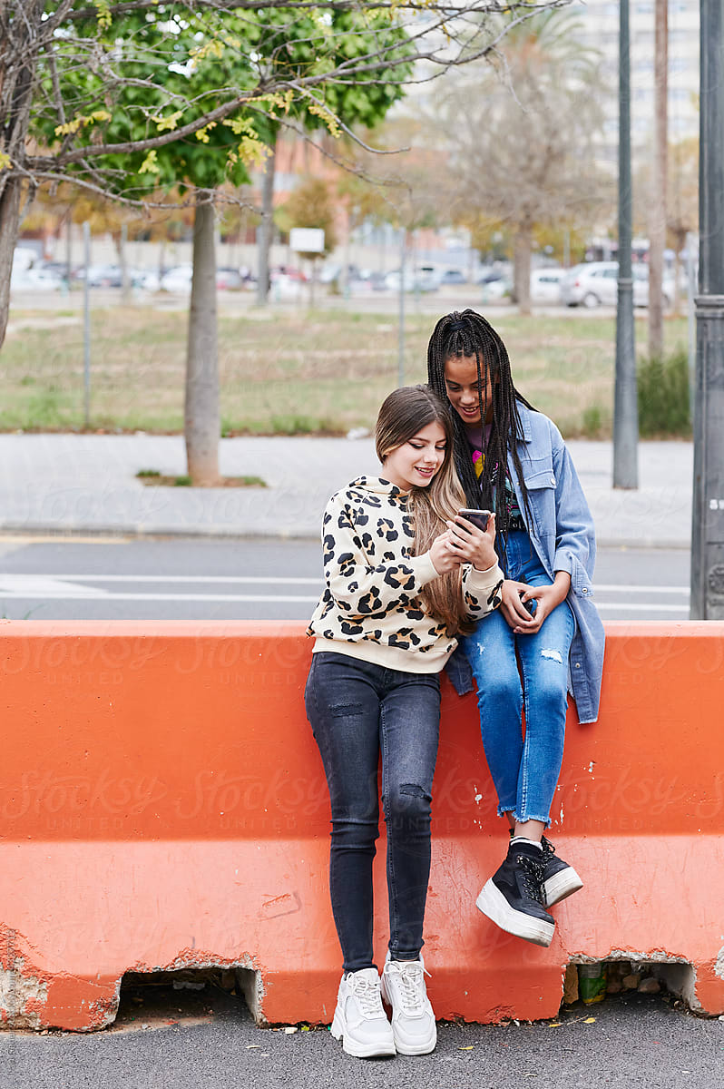 Teen girls using a phone in the city