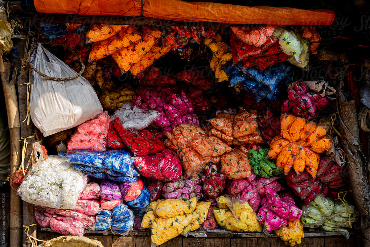 Bags of colorful flowers for sale at a street stall in Kolkata, India