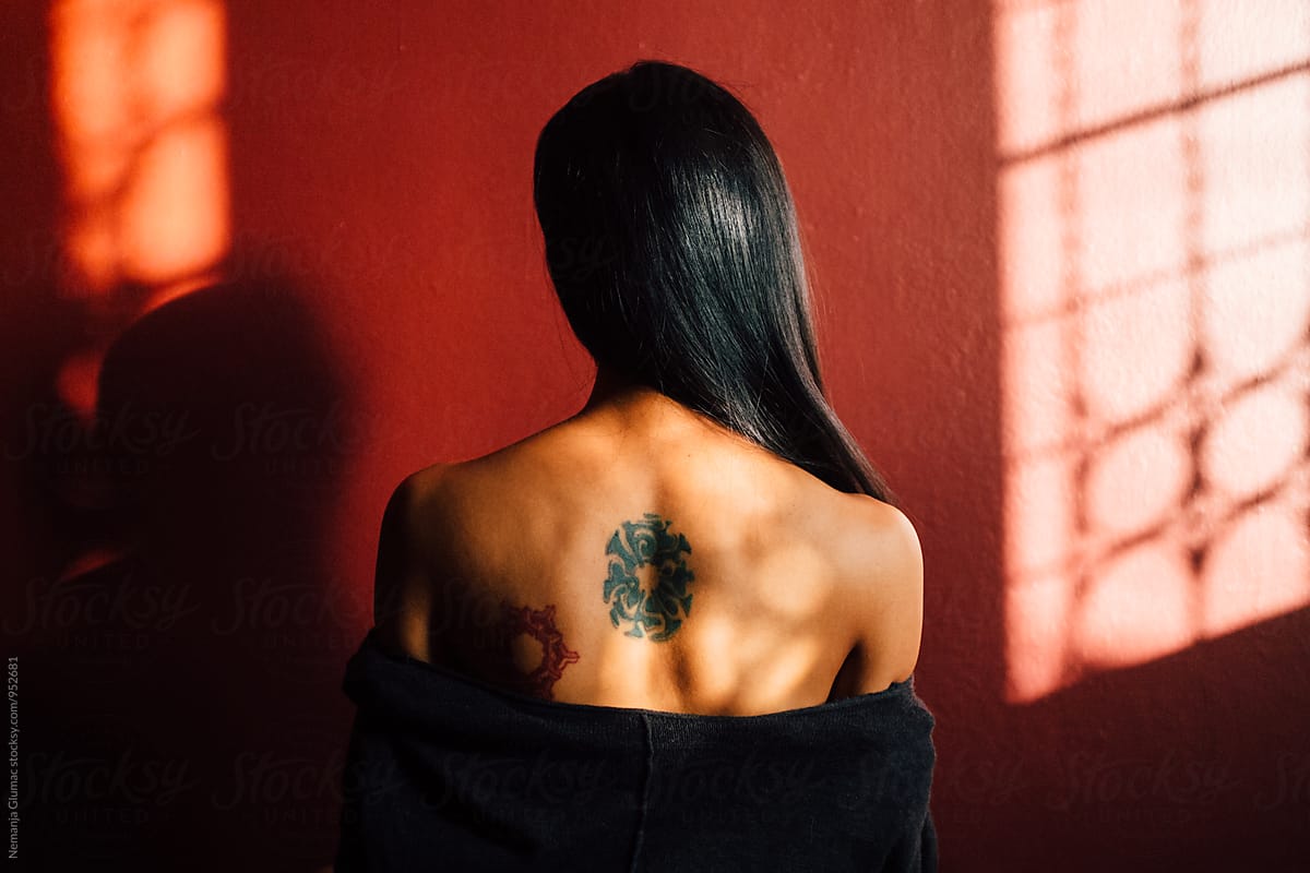 Sensual Thai Woman Facing Red Wall