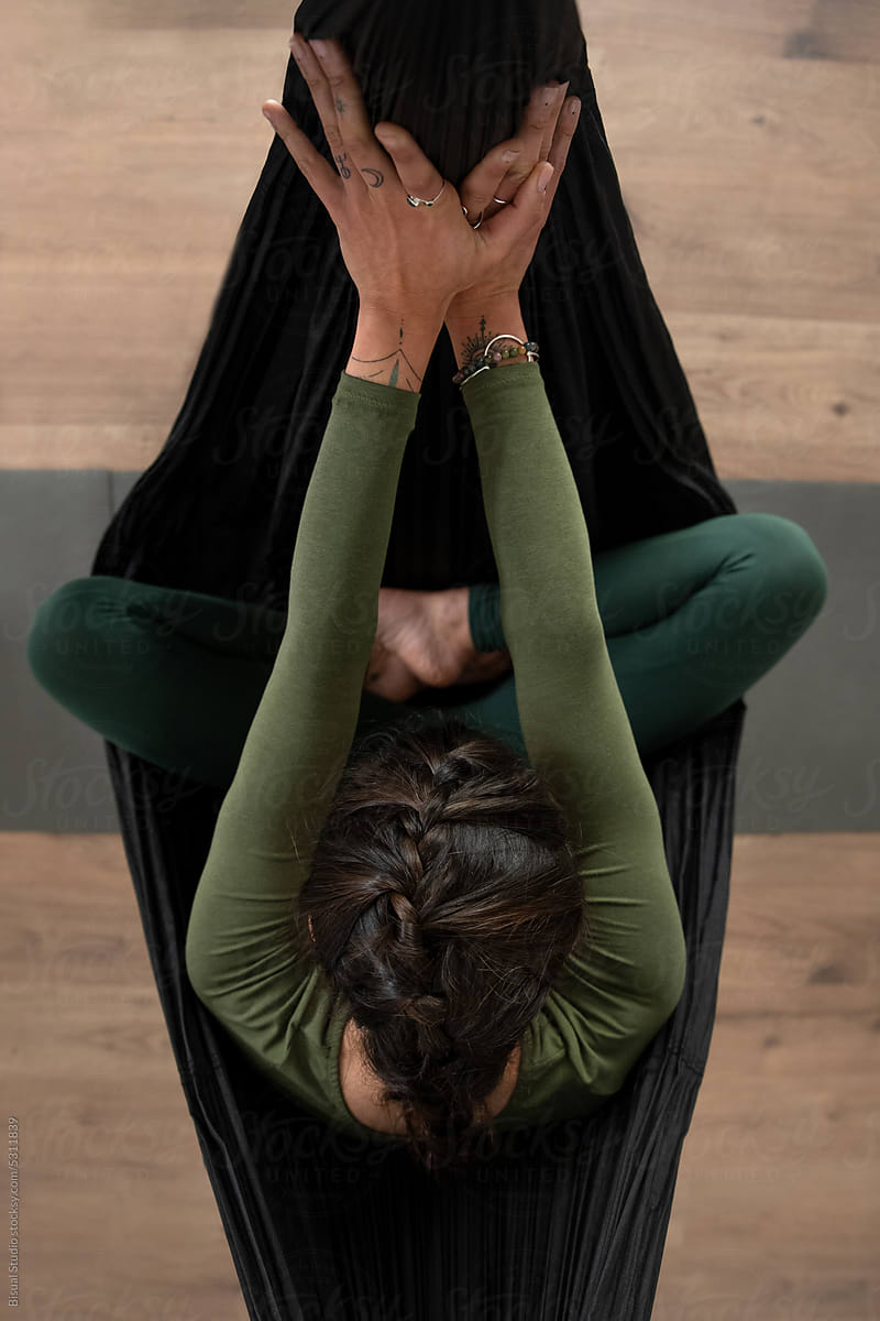 Woman practicing yoga in hammock