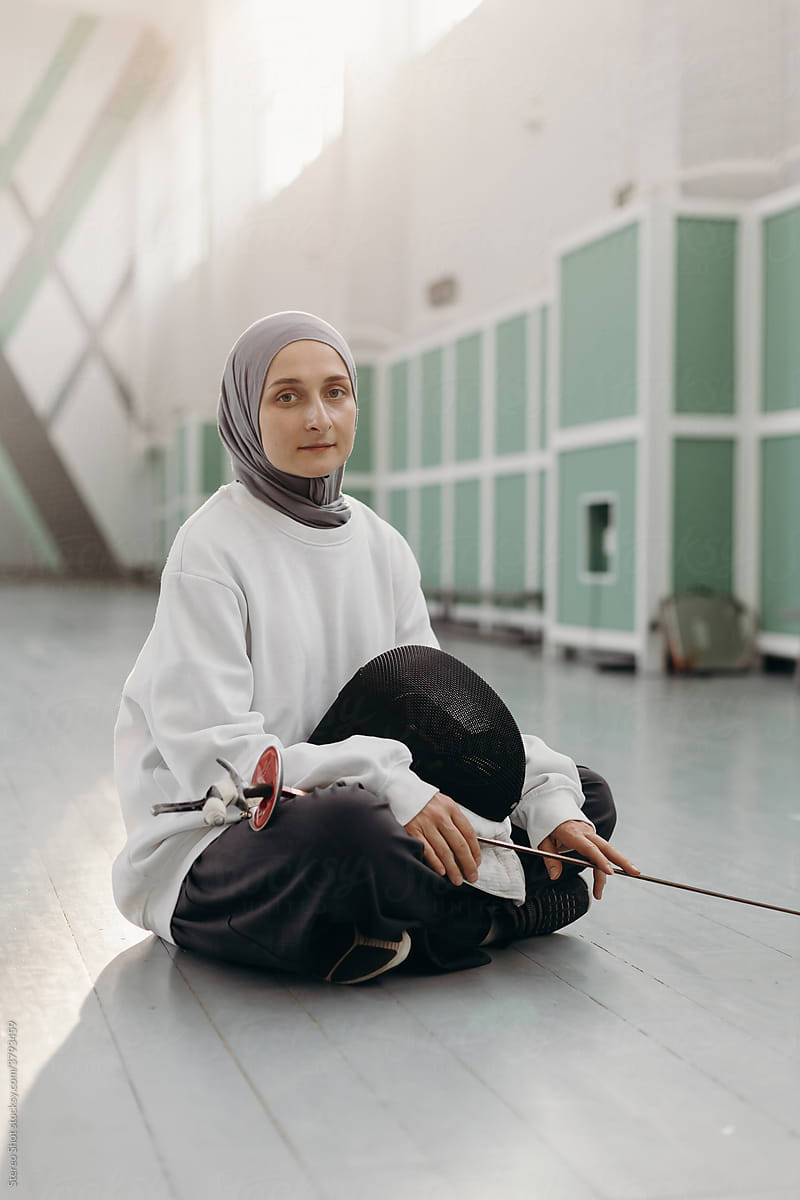 Muslim female fencer looking at camera in gym