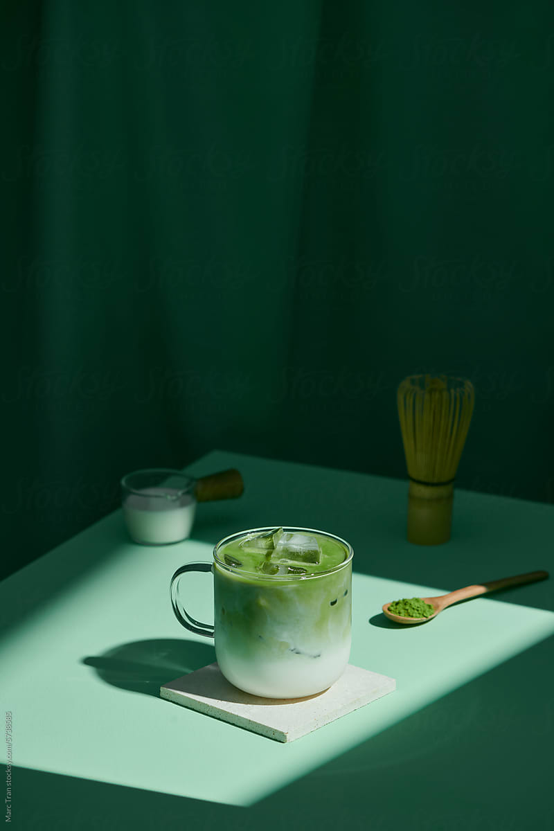 Matcha latte and accessories for making on green table