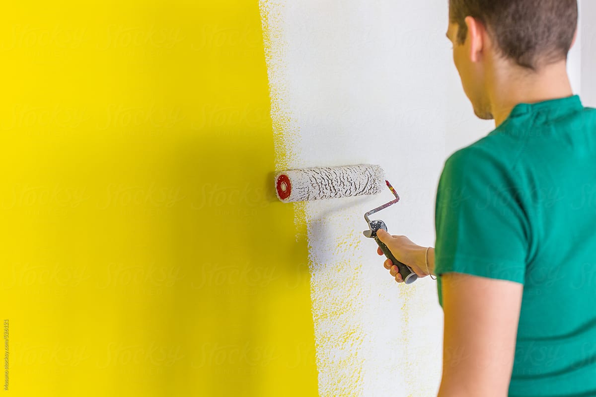 Man Painting Yellow Wall White
