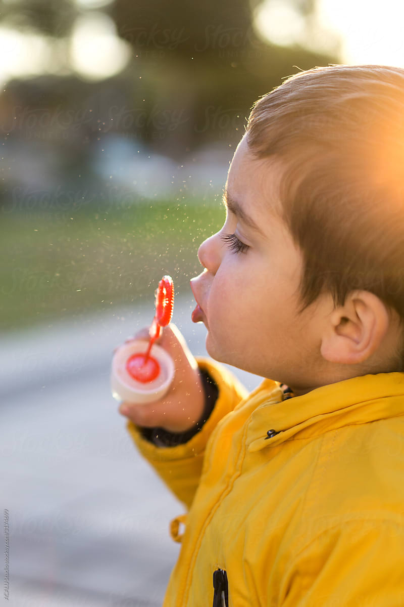 Little boy playing with soap bubbles
