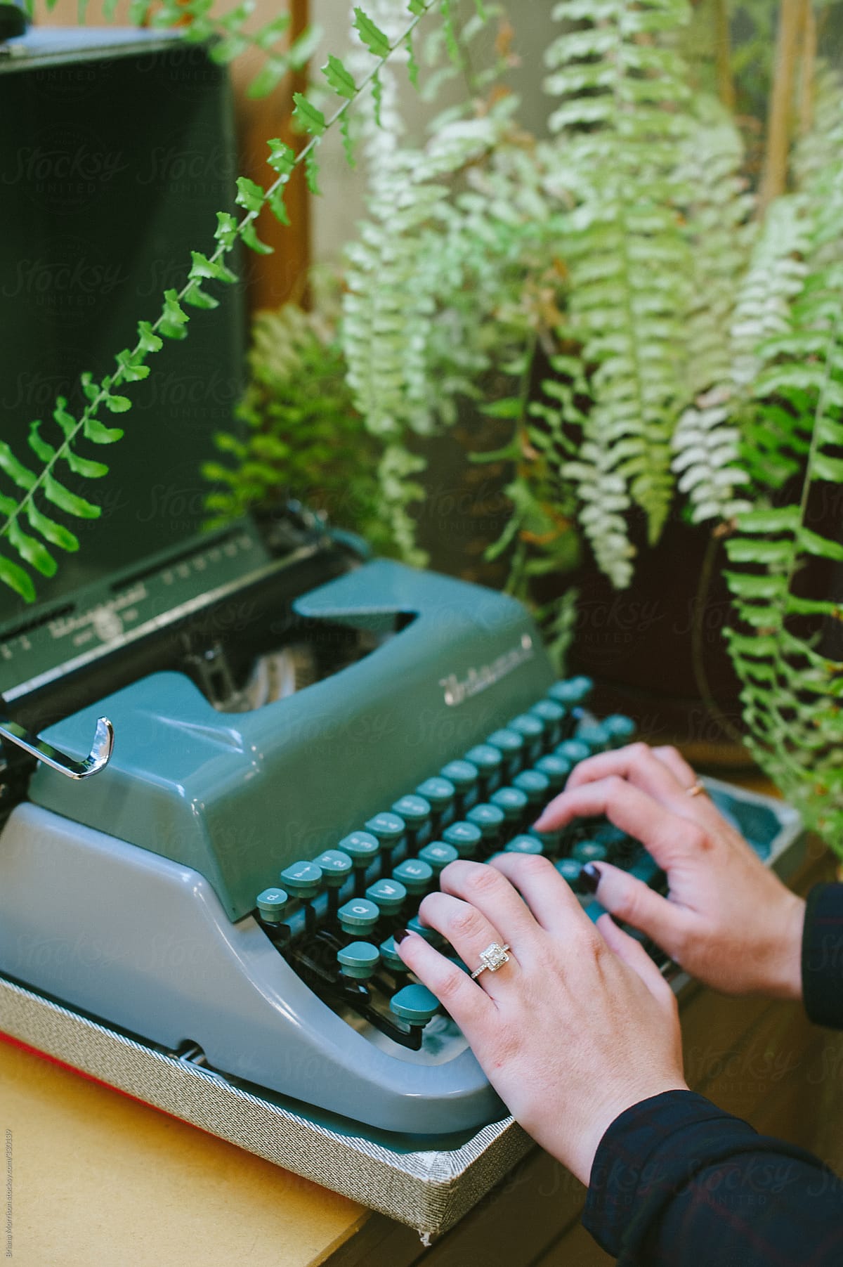 Hands at a Green Typewriter with Indoor Fern in the Background