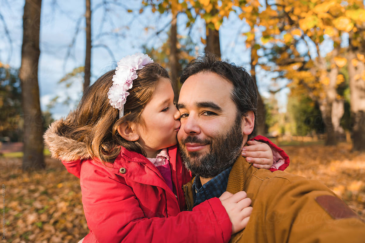Daughter Kissing Father in Autumnal Picture