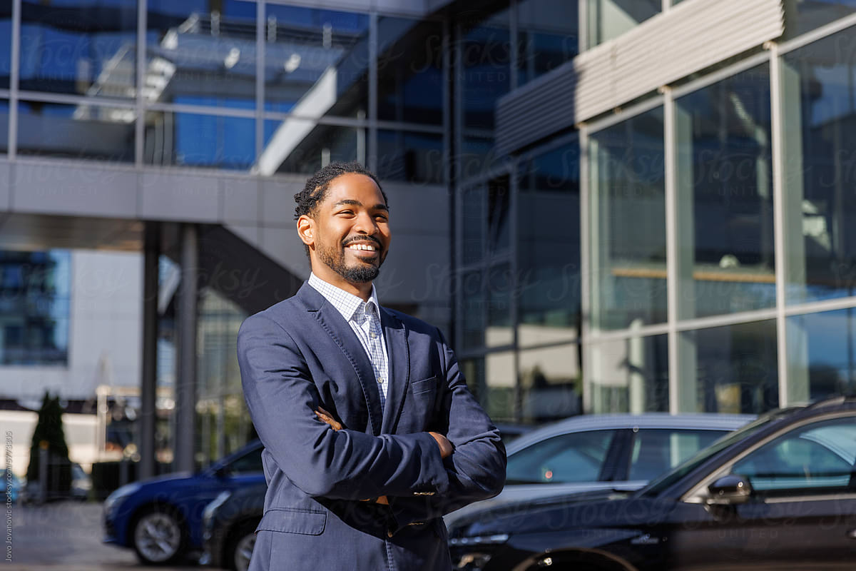 Smiling confident sales executive at car dealership