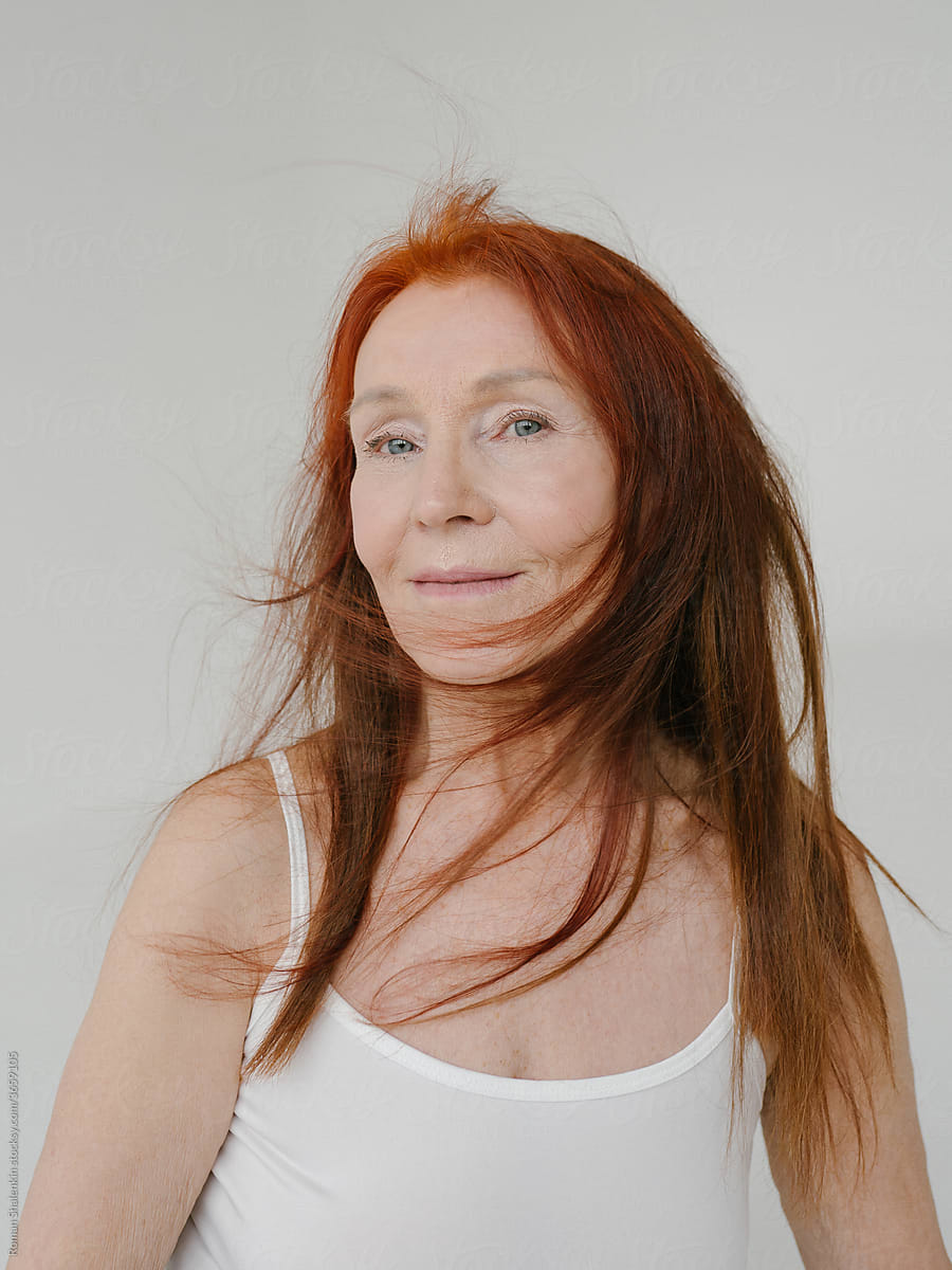 Portrait Of A Smiling Senior Redhead Woman With  Long Hair.
