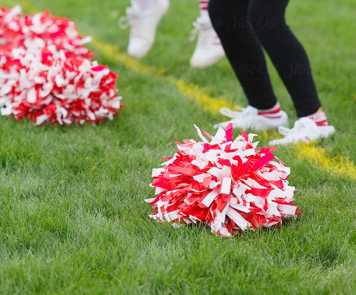 Cheerleading pom pom sits on grass of football field