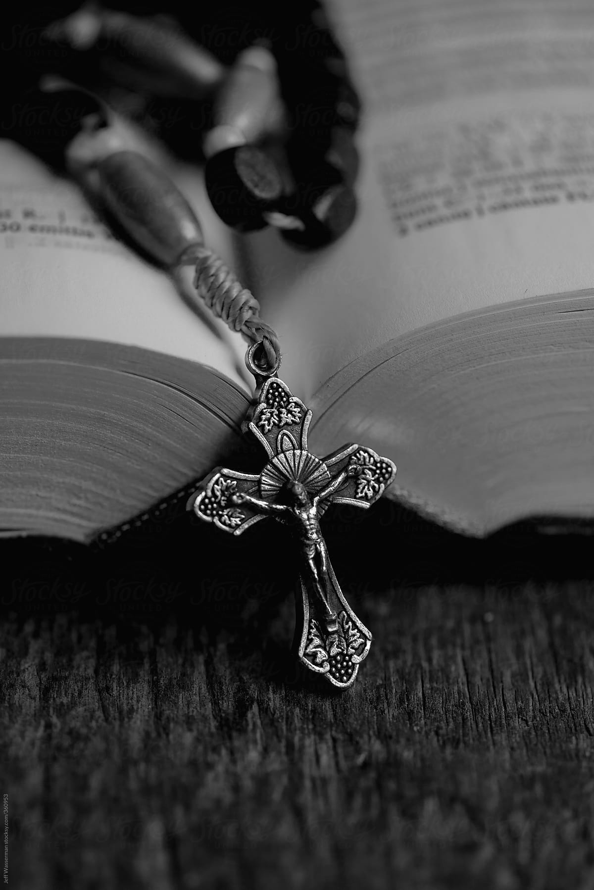 Rosary and Christian Bible Open on Table