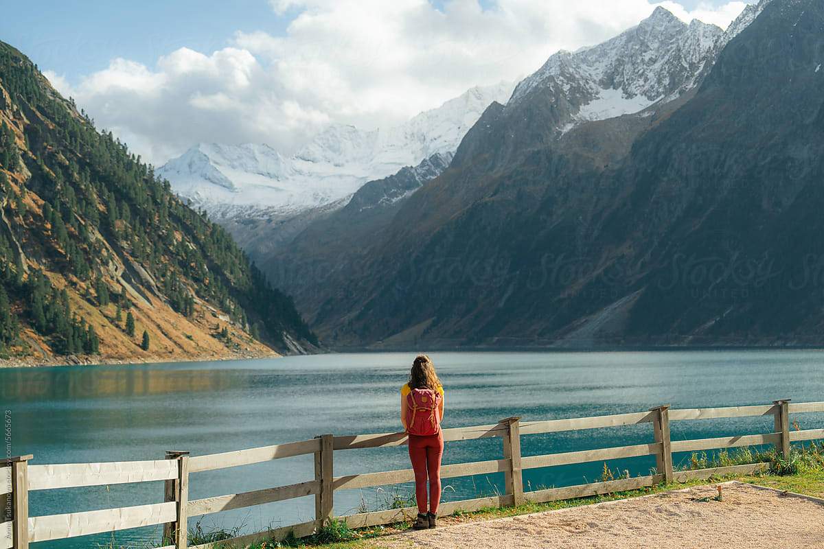 Woman standing on the background of the lake in Alps in autumn