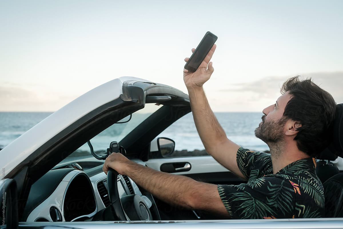 Man using phone inside convertible car