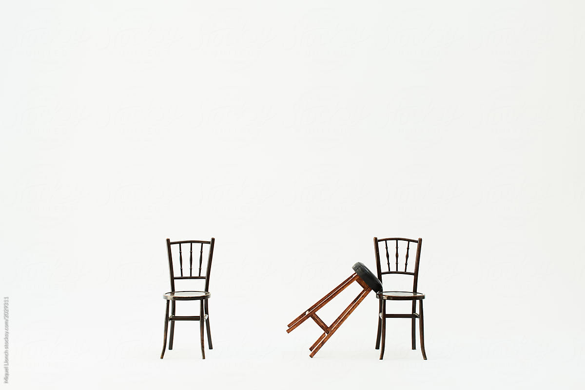 Two chairs and a stool leant over one of them against white background.