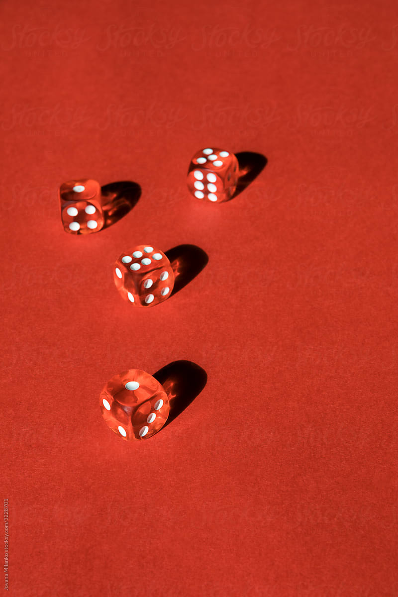 Four transparent red dice on red