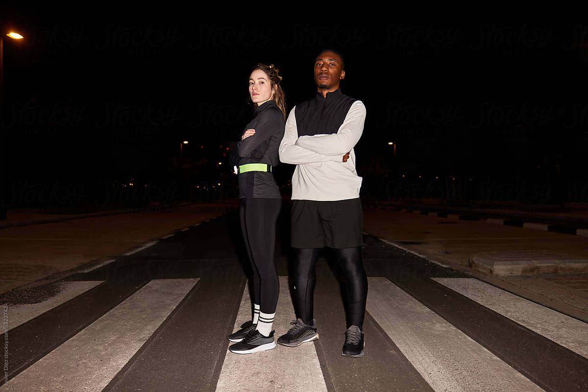 Confident multiracial athletes standing on street