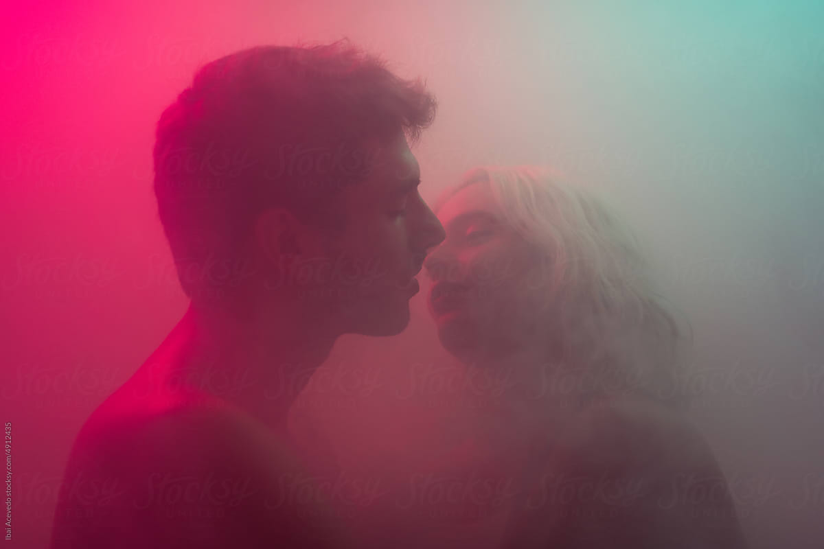 Dreamy portrait of kissing lovers inside smoke texture