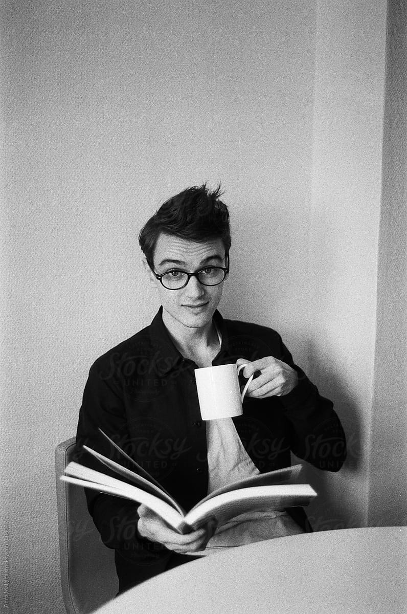 A man with a book and a coffee cup
