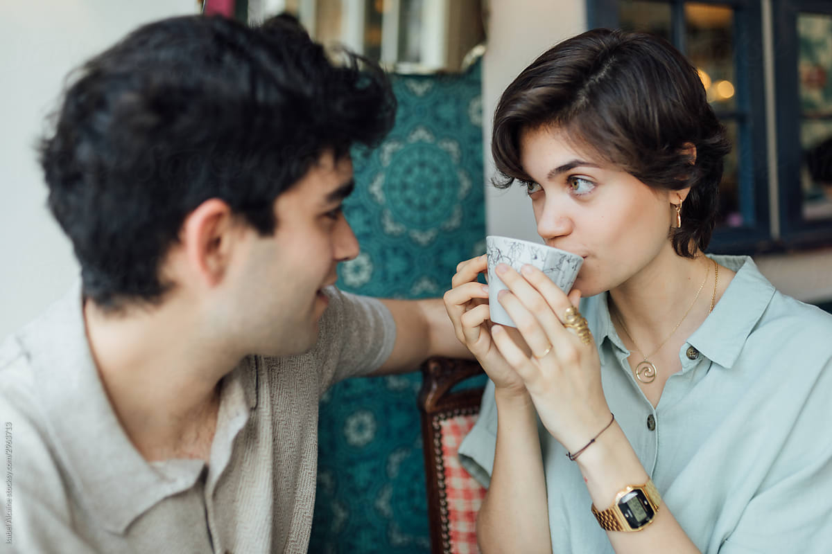 Couple in a coffee shop drinking coffee and cake