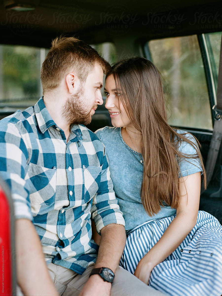 Loving young couple sitting in car