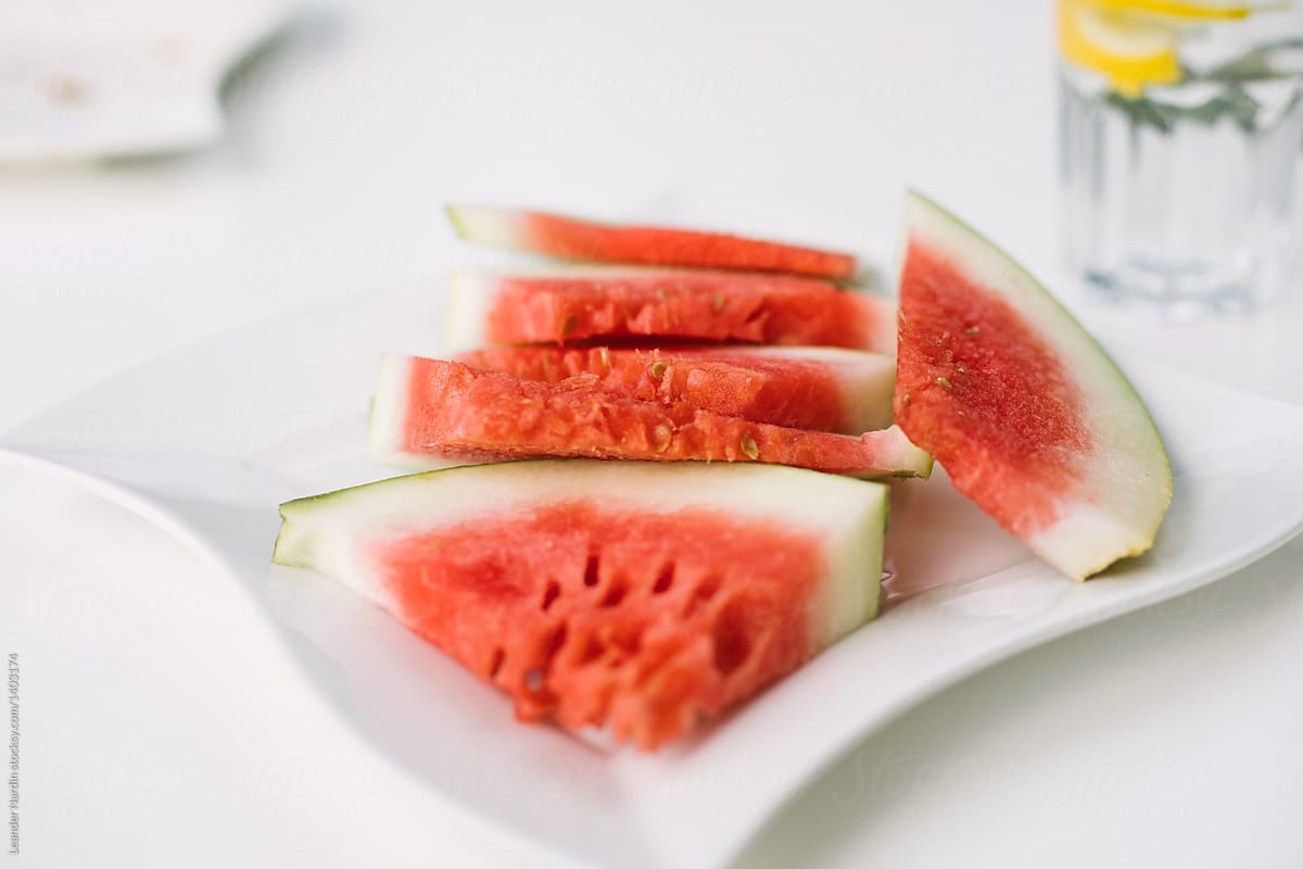 fresh water melon and water on white plate on white background