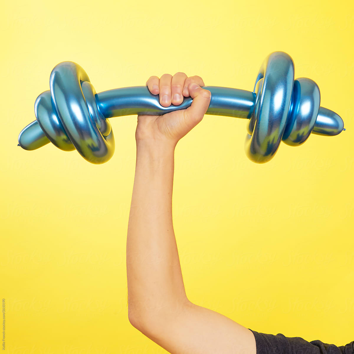 Person lifting a blue balloon dumbbell