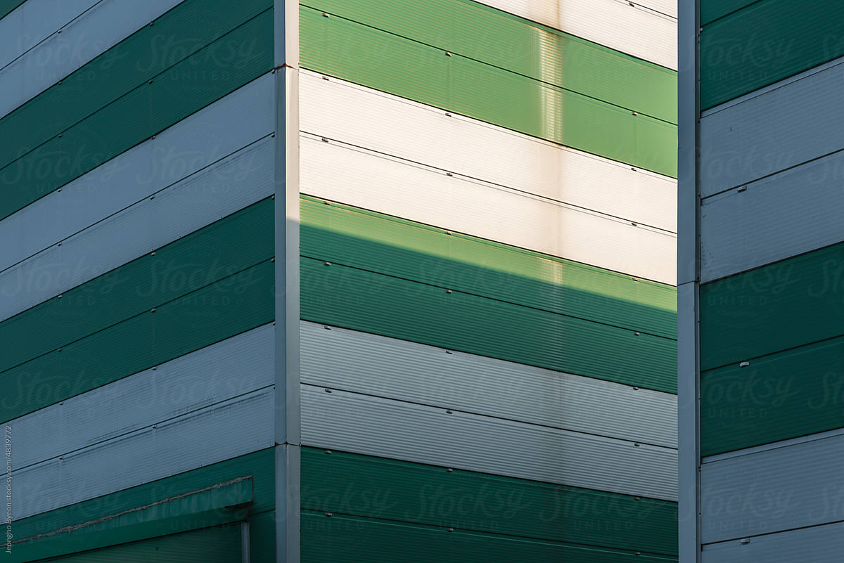 Sunlight on the walls of green striped buildings.