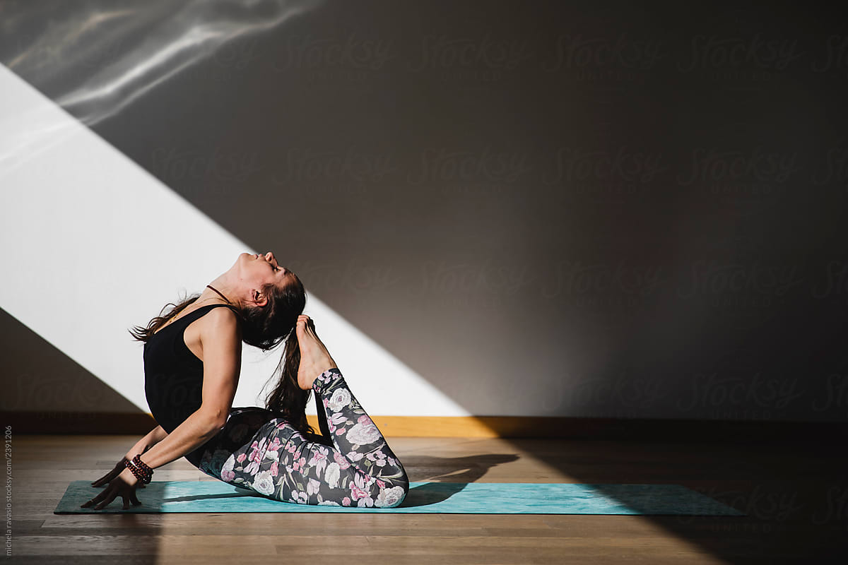 Woman Doing Back Arching Exercise During Yoga Practice By Michela