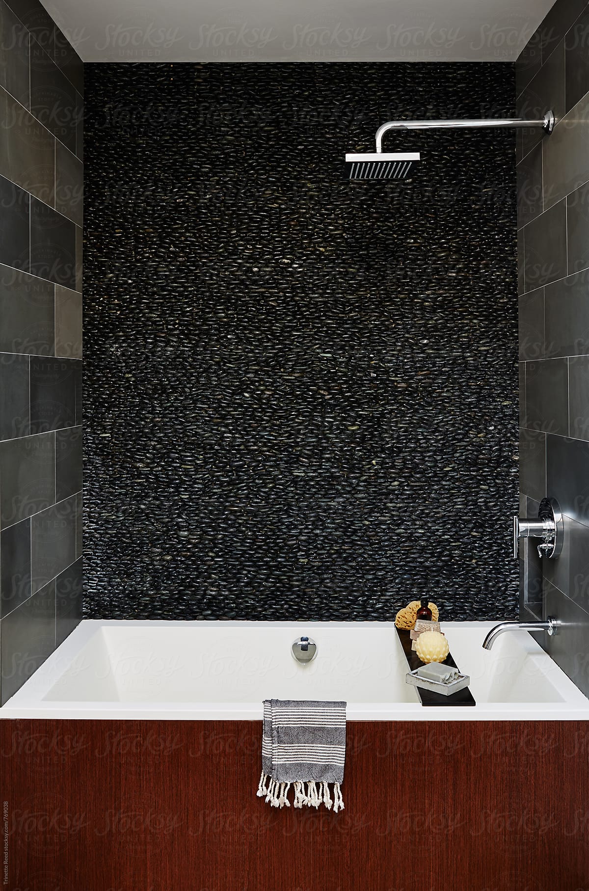 Modern design soaking bathtub in bathroom, pebble tile