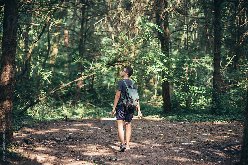 Young teen boy with a backpack exploring the forest