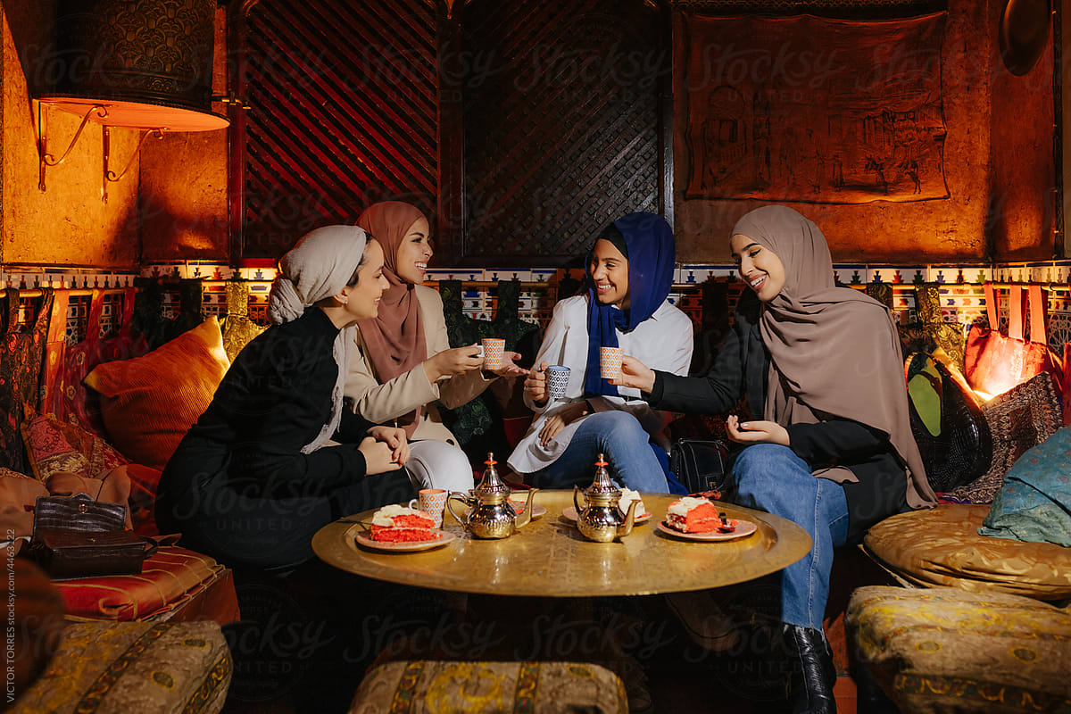 Group of diverse muslim friends sitting at tea house table