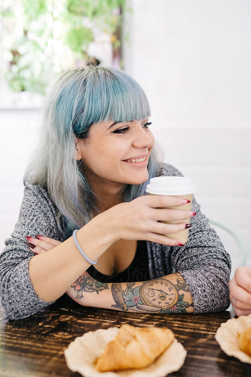 Cheerful stylish woman having coffee with friend