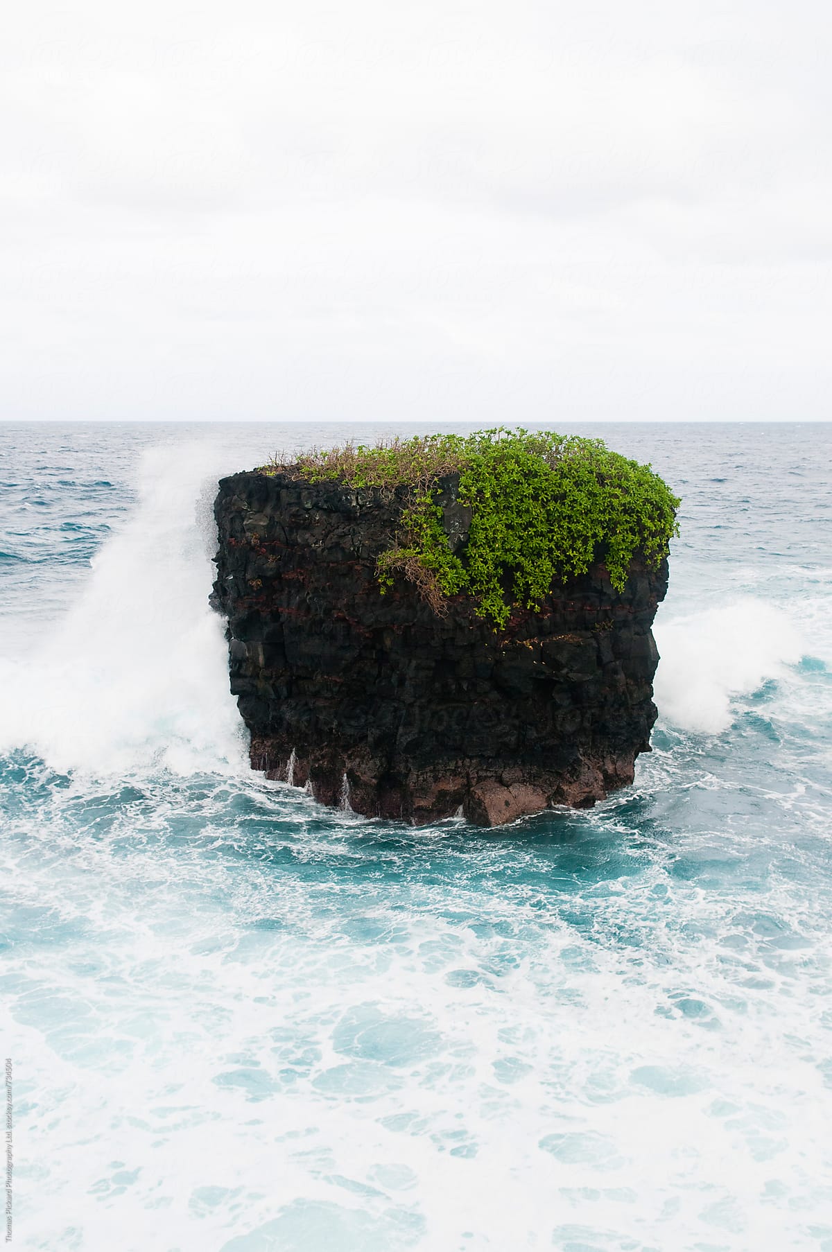 Waves breaking against a pillar, South Coast Samoa.