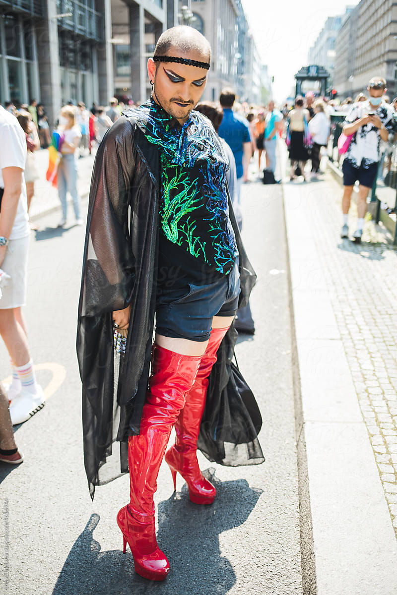 Man posing in red lace high heel boots during pride