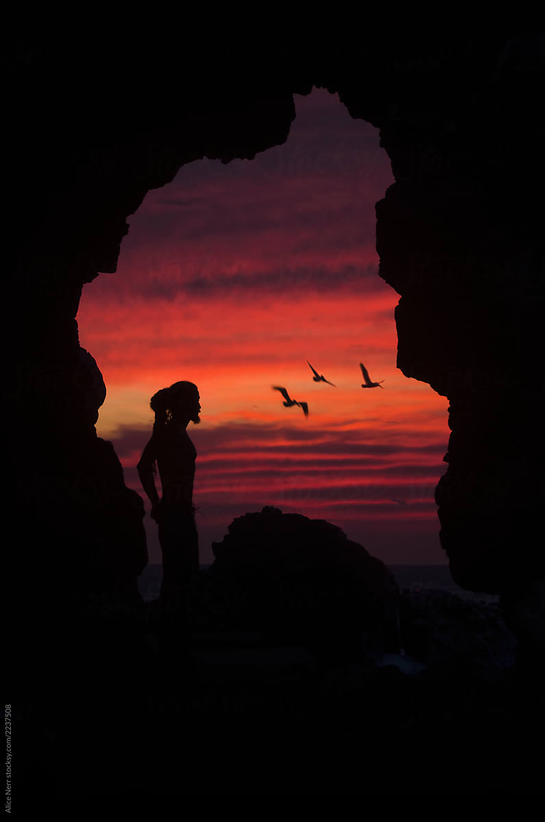 Man, pelicans, cave, sunset