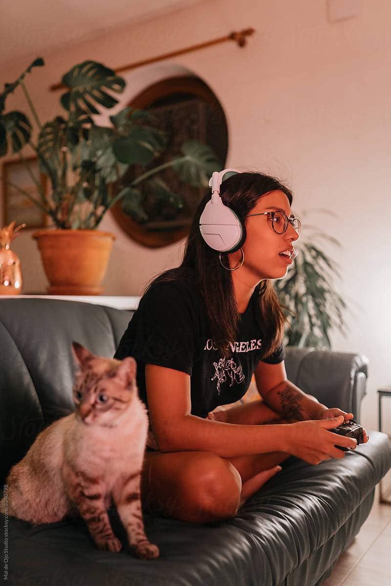 Woman with cat gaming at home